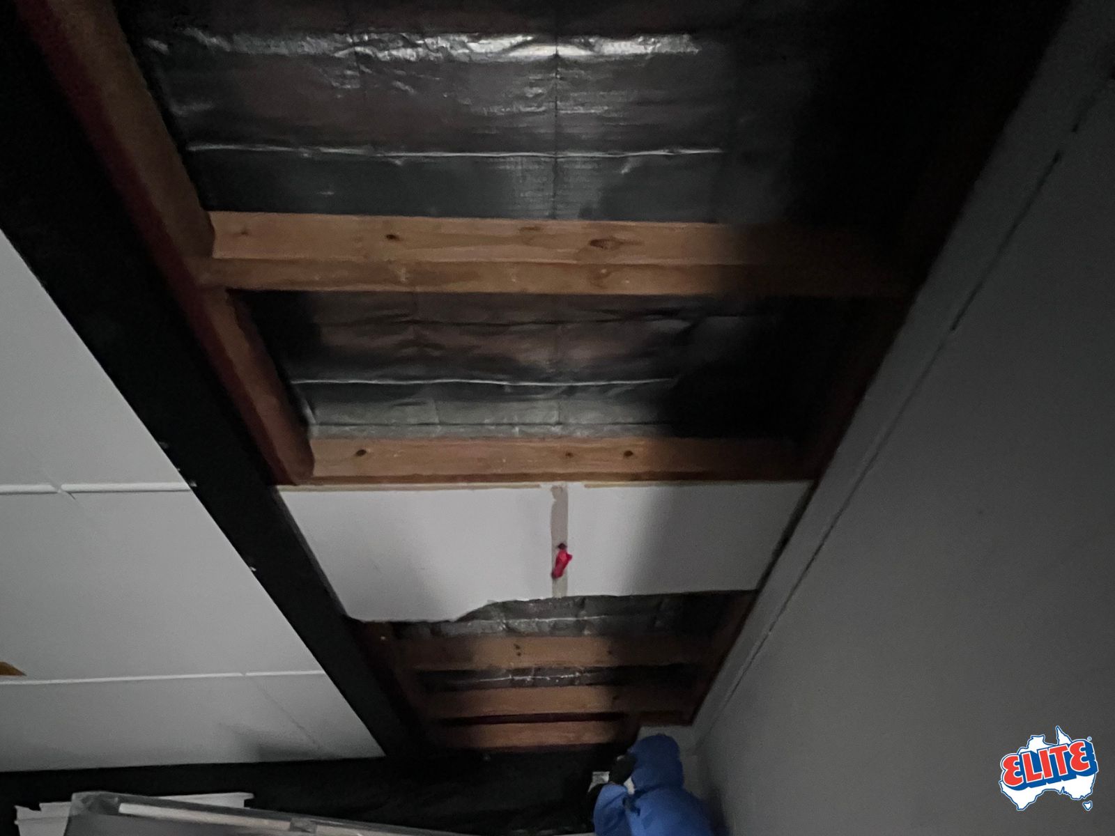 Storm-damaged asbestos roof with containment in progress